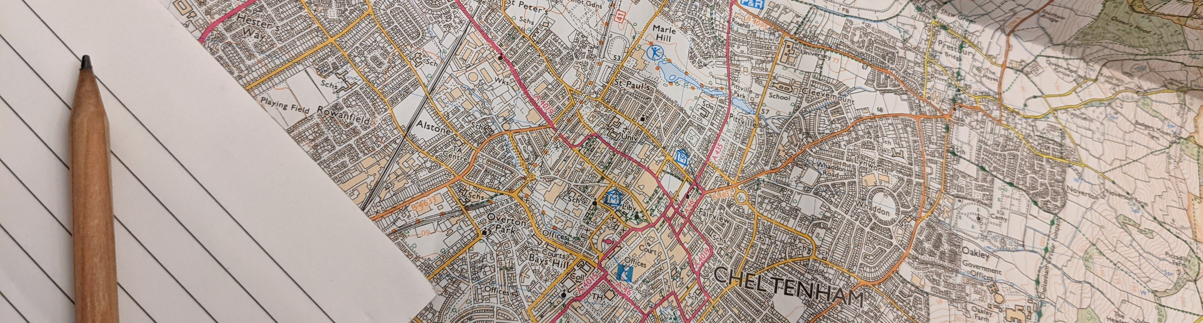 Map of Cheltenham with notepad and pencil